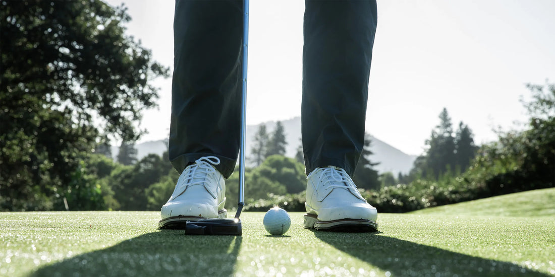 Picture of a person's feet on a golf course getting ready to putt while wearing Superfeet insoles.