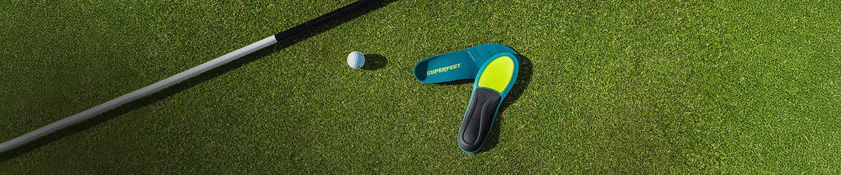Superfeet Insoles against putting green with a golf ball & golf putter in the background. 