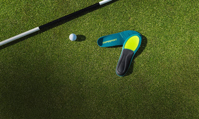 Superfeet Insoles against putting green with a golf ball & golf putter in the background. 