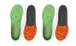 Two pairs of green and orange shoe insoles on a light gray background
