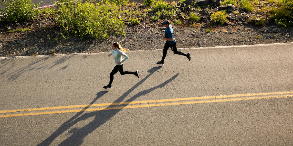 Man and woman on road running 
