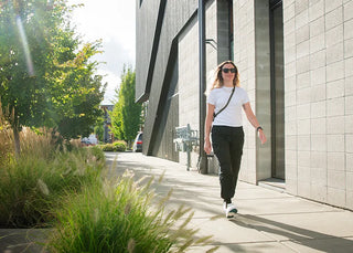 Woman wearing Superfeet insoles and walking on a sidewalk.